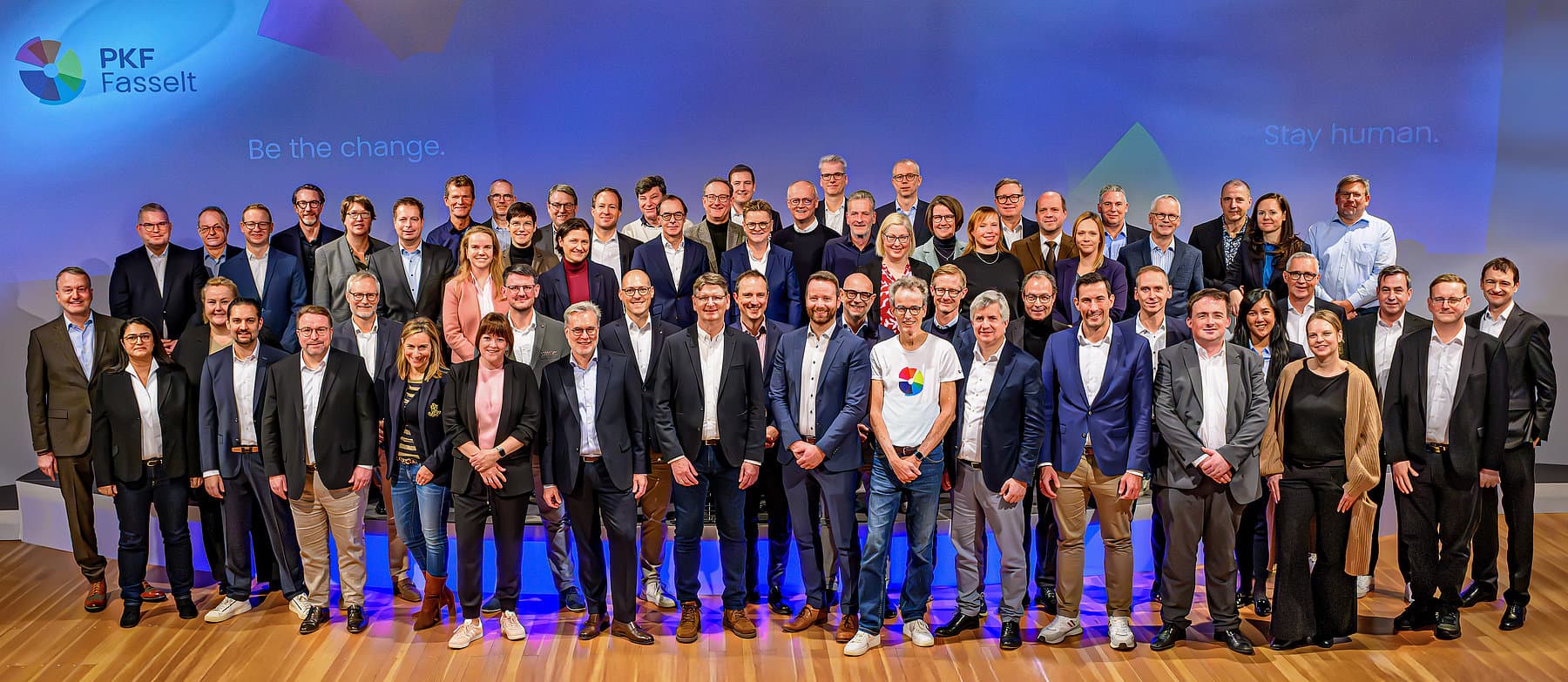 Gruppenfoto der Partnerinnen und Partner von PKF Fasselt auf einer Bühne