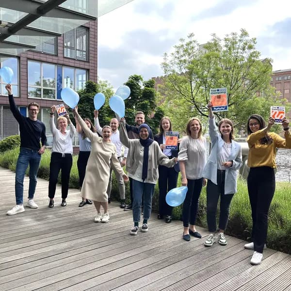 Team von PKF Fasselt feiert mit Luftballons und kununu-Top-Company-Siegeln