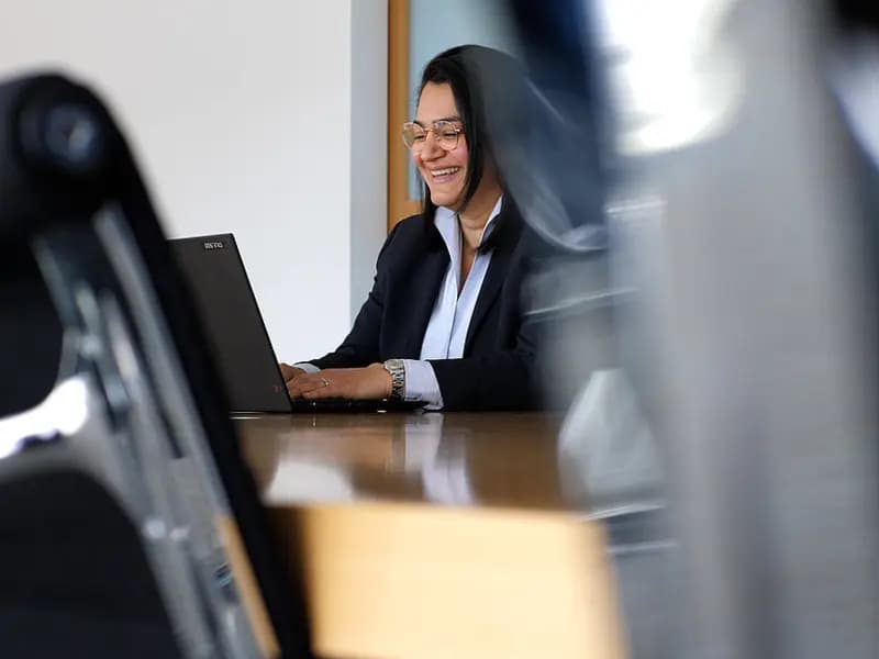 Jasmin Vahidi lacht bei der Arbeit am Laptop