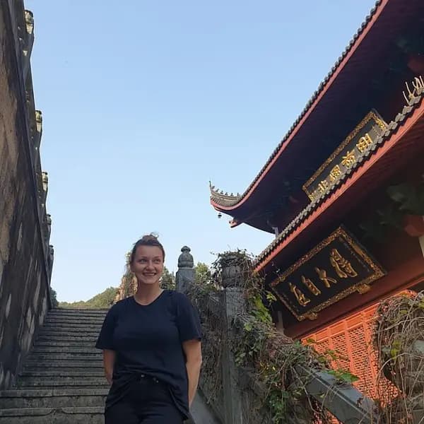 Kollegin bei einem Aufenthalt in China vor einem Tempel