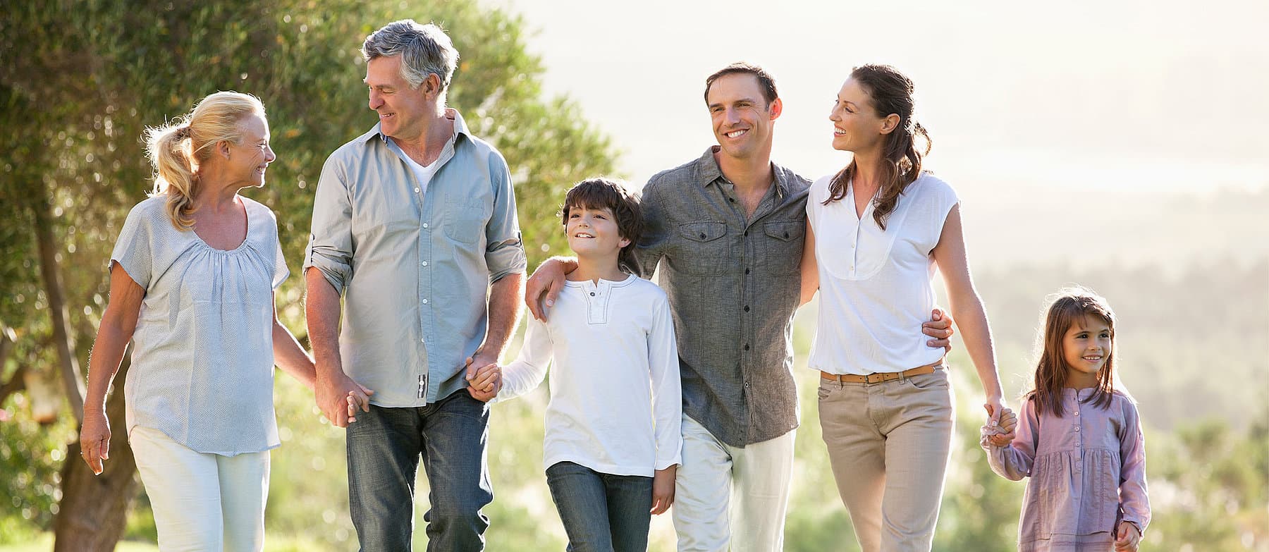 Glückliche Familie mit drei Generationen beim Spaziergang im Grünen