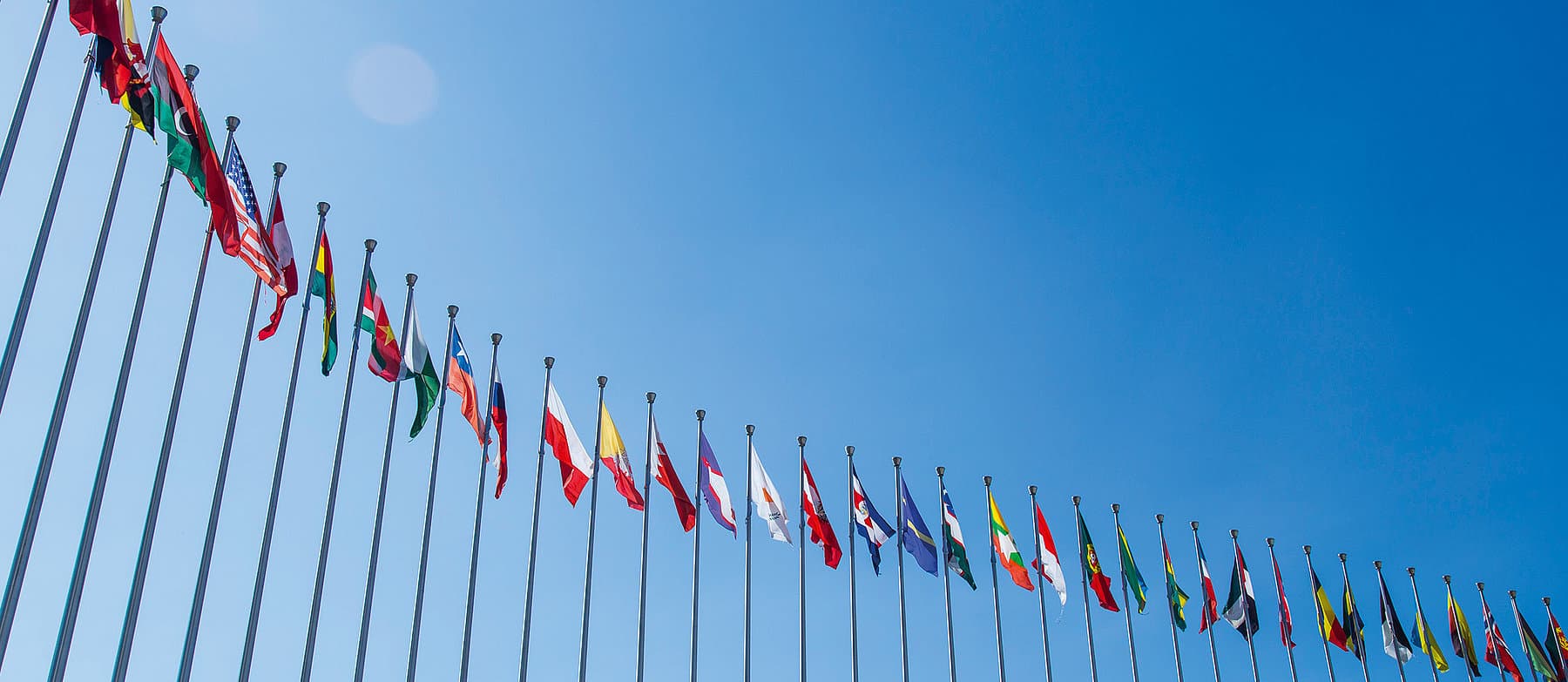 Internationale Fahnen vor blauem Himmel