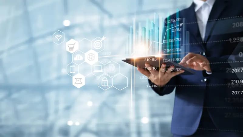 Berater mit Tablet vor eingeblendeten Diagrammen und Symbolen