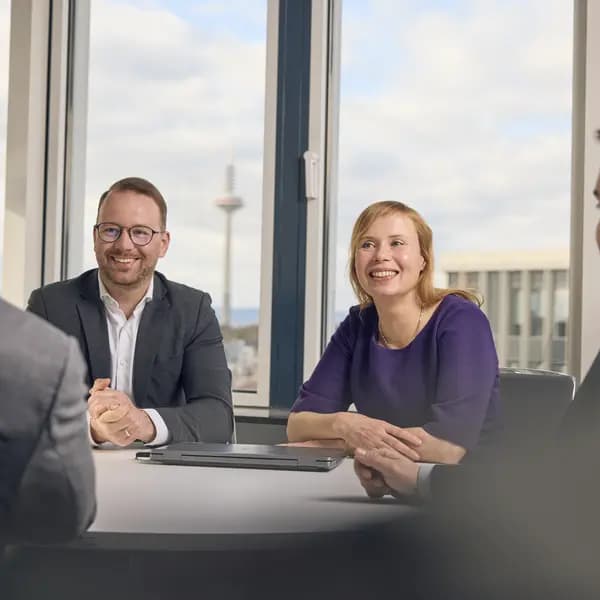 Kolleg:innen im Gespräch im Frankfurter Büro, im Hintergrund der Fernsehturm